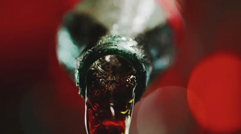 looking down coca cola bottle pouring out cola