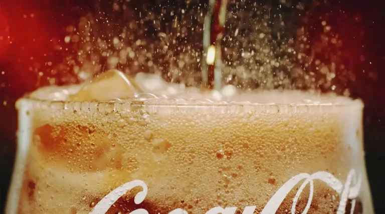 top of glass of coca cola frothy and fizzing