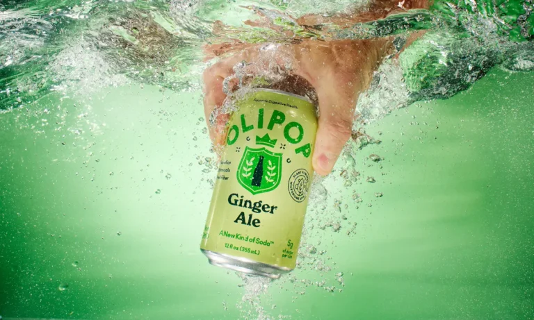Olipop Ginger Ale can being grabbed from tank of water