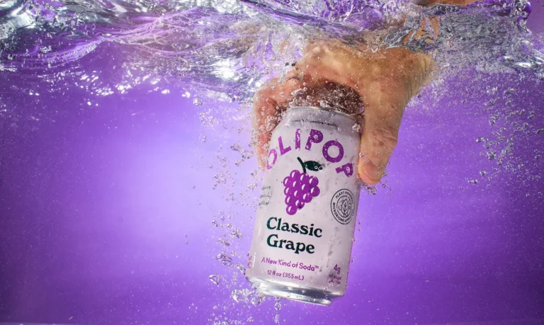Olipop classic grape can being grabbed from tank of water