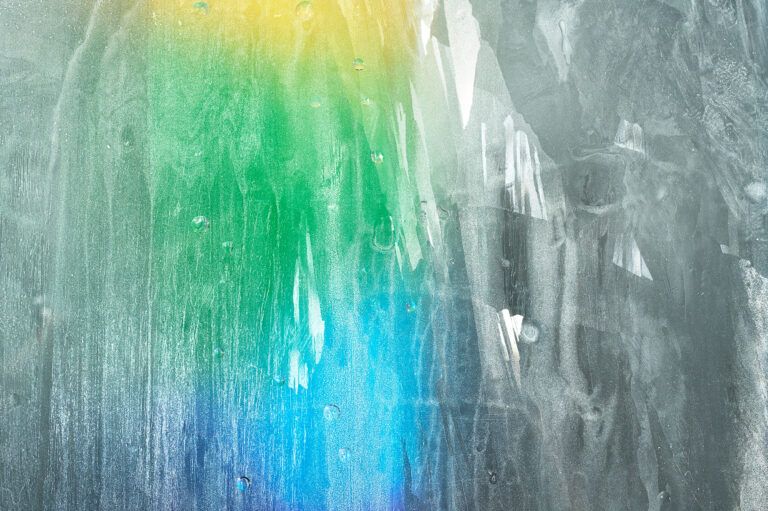 Abstract textured surface with vertical streaks of green, blue, and white light.