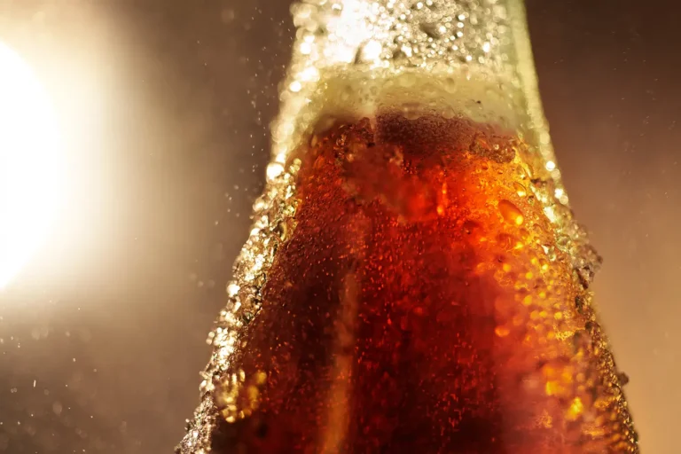 Extreme close-up of a beverage bottle with intense carbonation bubbles rising to the surface