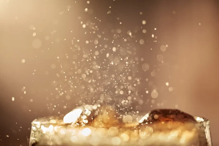Close-up of dark soda splashing and foaming at the top of a glass