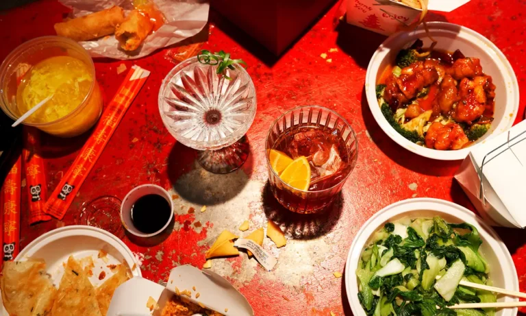 Baccarat Overhead view of a red table set with cocktails, small plates, and appetizers.