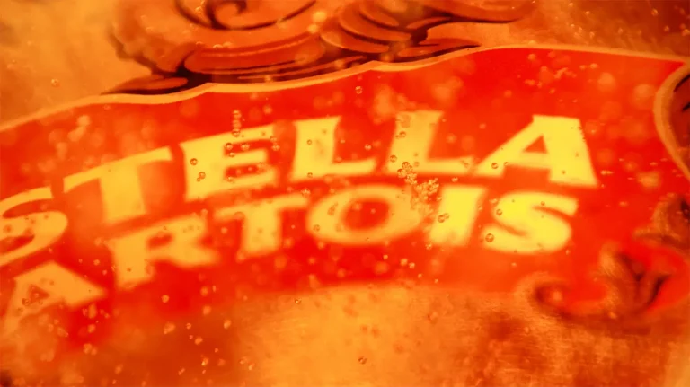 Extreme close-up of the red and gold Stella Artois logo on a glass.
